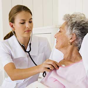 Cardiologo che sta visitando una donna anziana